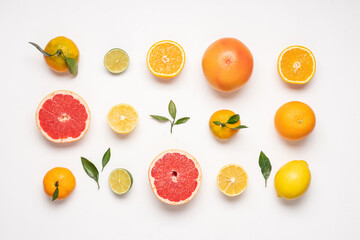 Creative neatly arranged food layout of citrus fruits and leaves on white background.  Flat lay...