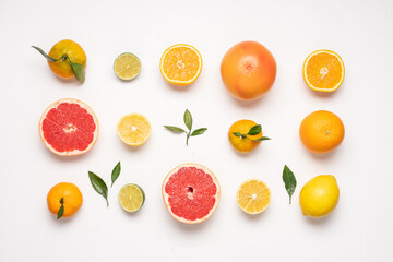 Creative neatly arranged food layout of citrus fruits and leaves on white background.  Flat lay juicy fruits concept