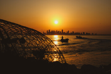 silhouette of the fishing boat and fisher man in Nurana island Bahrain