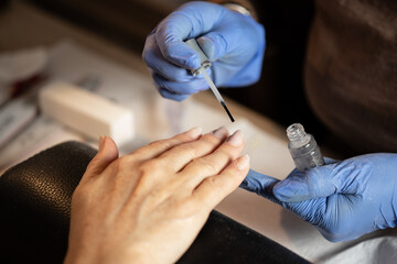 Closeup shot of a woman in a nail salon receiving a manicure by a butician