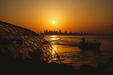 silhouette of the fishing boat and fisher man in Nurana island Bahrain