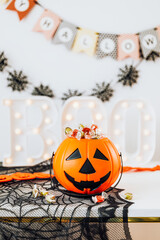 Halloween home decoration with a pumpkin basket filled with candies