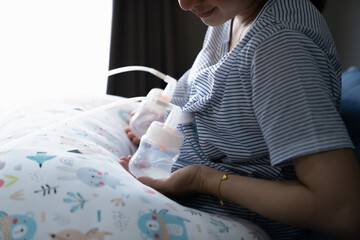 Mom use electric breast pump feeding for her baby.