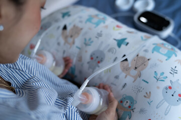 Mom use electric breast pump feeding for her baby.