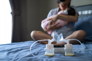 Mom use electric breast pump feeding for her baby.