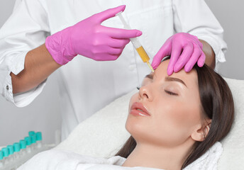 Cosmetologist does prp therapy on the face of a beautiful woman in a beauty salon. Cosmetology...