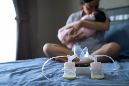 Mom use electric breast pump feeding for her baby.