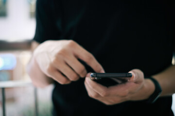 Closeup of male hand holding modern smartphone, man's hand using cellphone at night city, bokeh light, Selective focus.