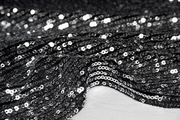 Beautiful sequin embroidery on fabric tulle mesh. Abstract ornamental curls. Textile industry black white background	
