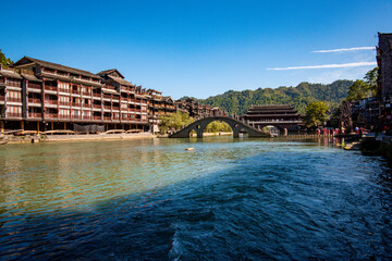 the river, the boat, stone bridge and the old houses at ancient phoenix town in the morning at...