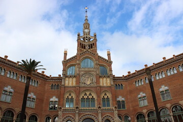 Fototapeta na wymiar fachada del Hospital de la Santa Creu i Sant Pau en Barcelona, un edificio modernista con palmeras en su entrada 