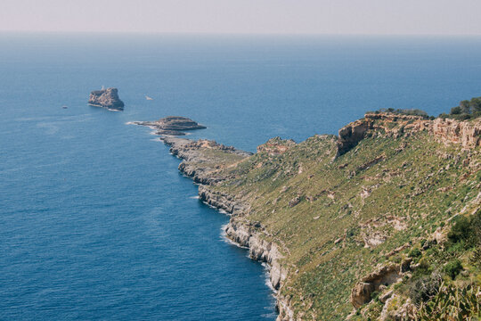 Punta de tierra que se adentra en el mar y acaba con islotes y un faro en Mallorca