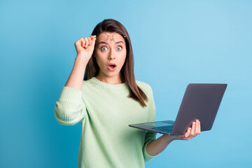 Photo of astonished girl hold laptop raise spectacles stare in camera stupor isolated over blue...