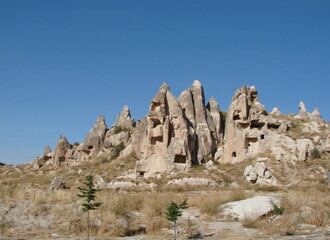 Panorama of a mountain valley covered with rocks of unusual shapes on a background of sunny blue sky over the horizon.