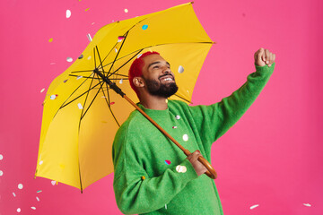 Happy african american guy smiling while posing with umbrella