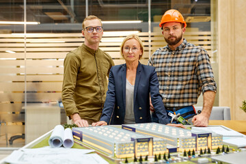 portrait of successful team of architect, investor and director posing at camera, they gathered to plan construction project, search new ideas. partnership and cooperation