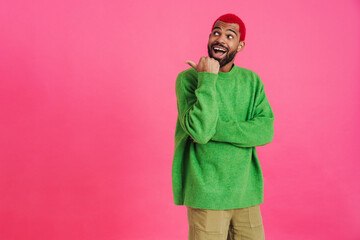 Excited african american guy smiling and pointing finger aside