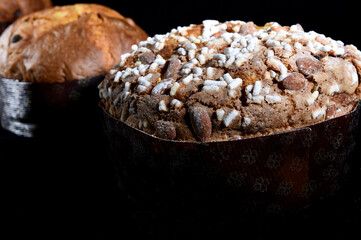 artisanal panettone whit almonds on black background whit cutting light