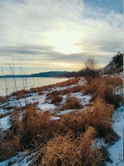 snow covered river bank against the background of the morning sky in the autumn landscape