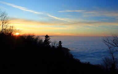 Winter sunset sky from mountain with fog  down in lowloand