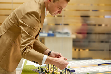 concentrated architect man working with building layout, architectural plan. male in formal wear check the sketching a construction at work site, engineer concept