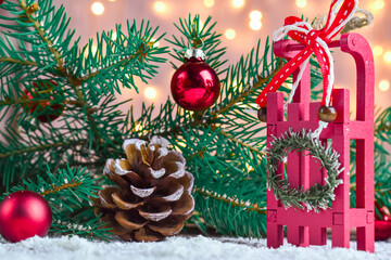 Wooden sleigh on a snow-covered background with a spruce branch