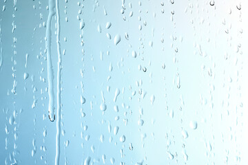 Rain drops on glass blue background