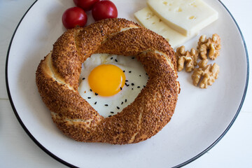 Delicious breakfast plate consisting of bagels, eggs, cheese, walnuts and tomatoes.