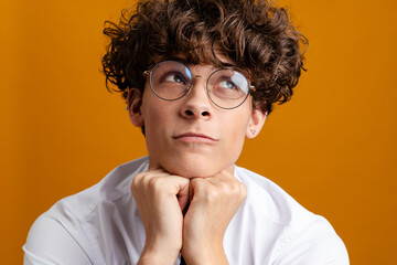 Pensive young man student wearing glasses isolated