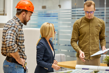 creative architects working together in office, caucasian team of designer, architect engineer working on scale model building, giving presentation to client.