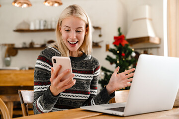 Positive woman indoors at home using laptop computer