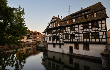 Fototapeta na wymiar Old town water canal of Strasbourg, Alsace, France. Traditional half timbered houses of Petite France at dawn