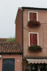 Fototapeta na wymiar classic, small brick-colored house in a small Italian town, with balconies and flowers