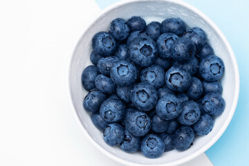 Fresh blueberries in bowl isolated on white. Top view.