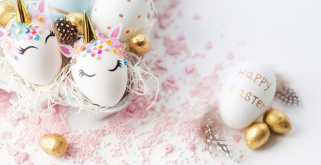 Banner. Minimal easter concept. Easter eggs in the form of a unicorn, and with a gold pattern on a...