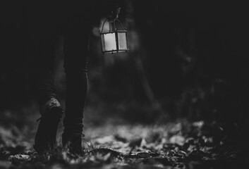 Fototapeta premium Man walking with a lantern in a woods