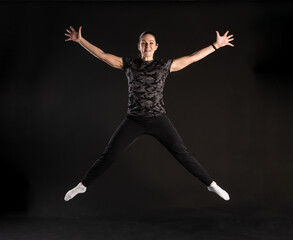 Fitness in the jump. Engaged in sports on a black background Smiling with a beautiful smile