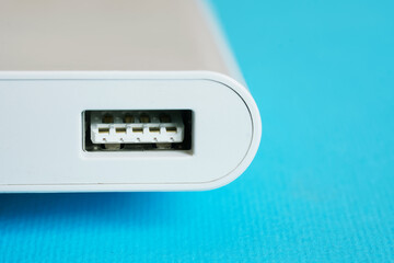 USB upstream port on a modern gadget: power bank or laptop dongle. Blue background. Close-up. Free...
