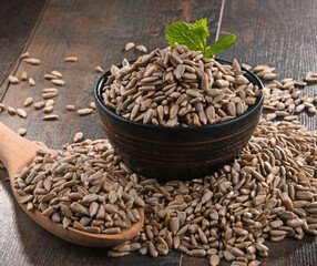 Composition with bowl of shelled sunflower seeds on wooden table