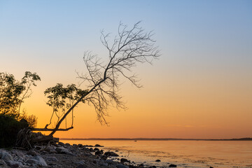 Sunset at the rocky Baltic Sea coast with mirror-smooth sea.