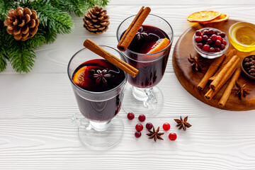 Two cups of mulled wine, spices and dry citrus fruits warming christmas drink