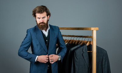 perfect male. formal and office wardrobe. businessman. confident tailor designing male jacket. handsome sartor with tape measure. male beauty and fashion. bearded man tailoring clothes
