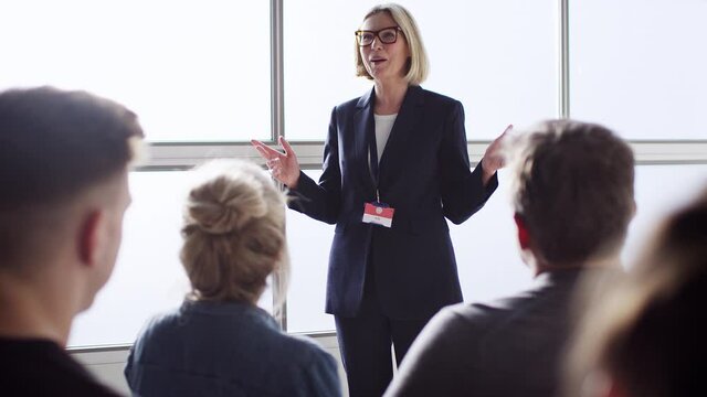 Mature businesswomen giving presentation to colleagues at conference - shot in slow motion