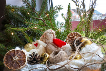 Gift box with toys for Christmas. Garland on the branches of the unit, an angel - a Christmas toy,...