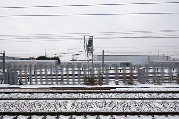 train tacks in the snow side view with cable lines telephone electric running over head winter white cloudy
