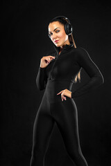 Sport concept. Sporty fit woman, athlete with headphones make fitness exercises on black background.