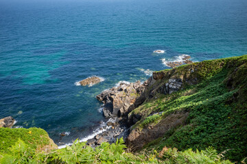 Fototapeta na wymiar Cornwalli, UK: Cliffs and a beautiful blue sea along the Cornish coast path. Between St. Ives and Pendeen