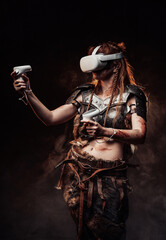 Portrait of a barbaric woman from nord dressed in medieval armour posing in dark background with virtual reality headset.