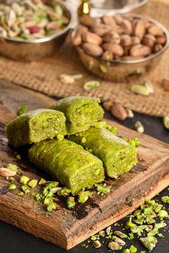 World famous baklava making in Gaziantep. Pistachio wrap presentation on wooden board. Turkish ramadan dessert Baklava with pistachio. The Turkish name of this dessert variety is fıstıklı sarma.