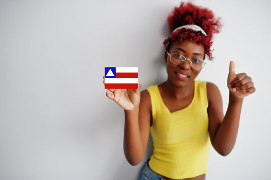 Brazilian woman with afro hair hold Bahia flag isolated on white background, show thumb up. States of Brazil concept.